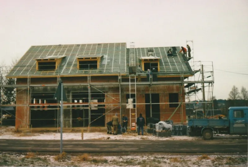 Farbfoto: Rohbau des Gerätehauses mit Gerüst und Dachlattung im Winter