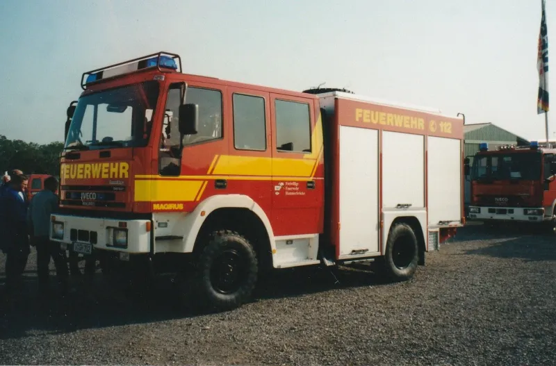 Farbfoto: das neue rot-weiß-gelbe Löschfahrzeug von Iveco Magirus bei der Abholung
